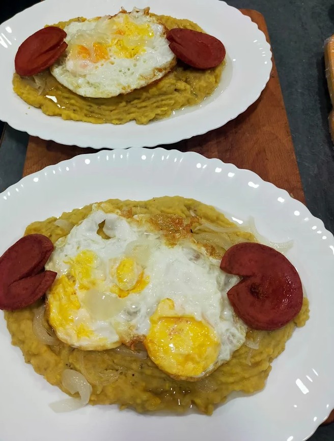 Deliciosos platos de mangú con salami y cebolla coronados por un gran huevo frito.